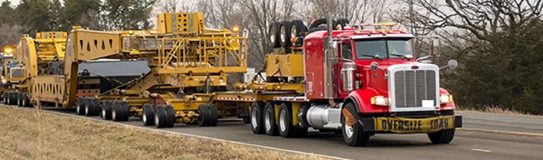 heavy equipment loaded on trailer hauled by truck